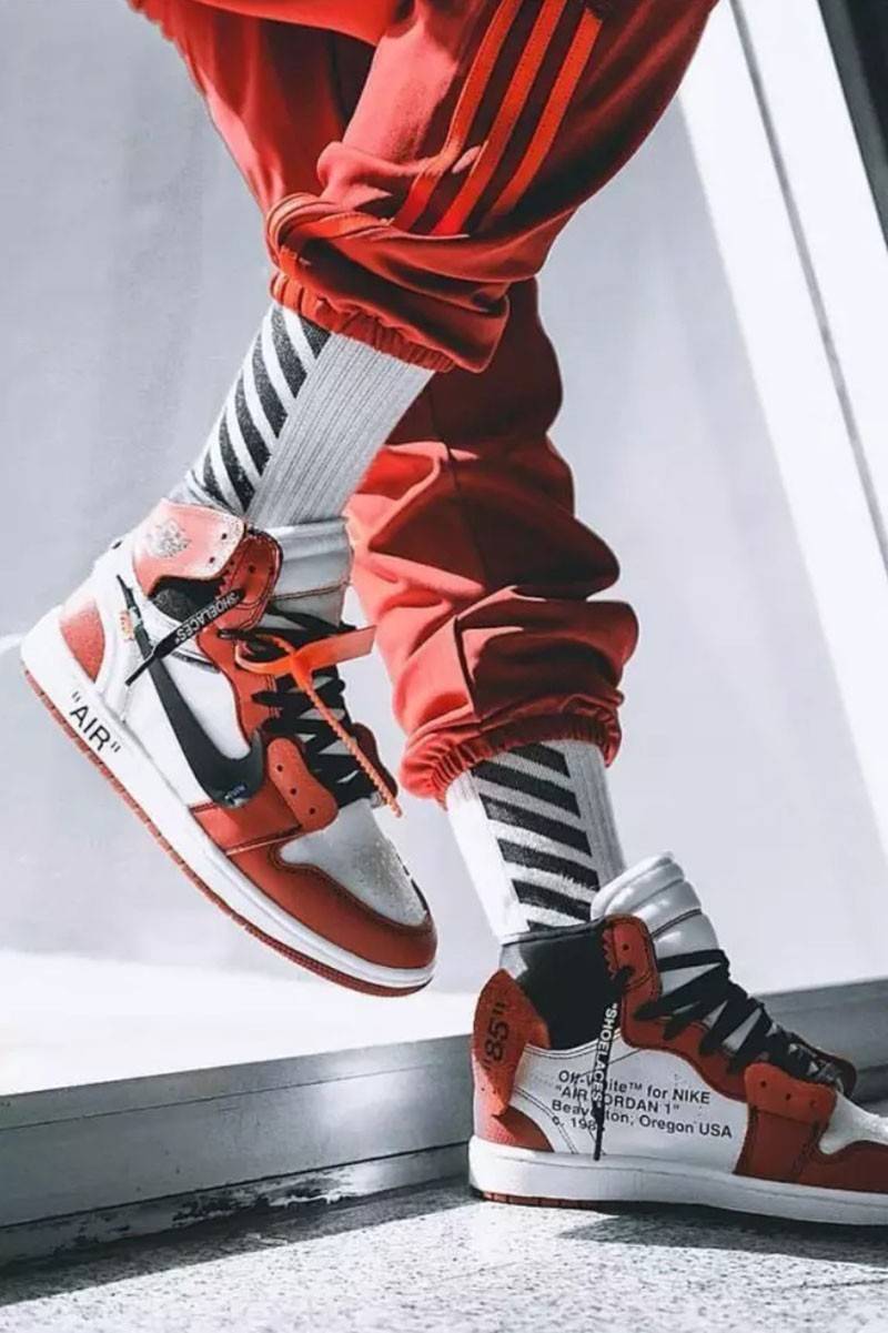 Người đeo giày Jordan 1 Off White màu đỏ