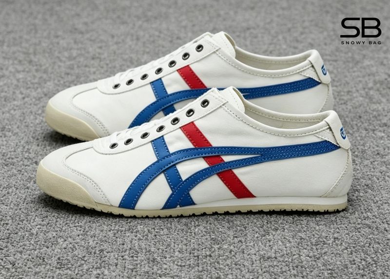 Cận cảnh một đôi giày Onitsuka Mexico 66 với thiết kế đặc trưng, đặt trên nền gỗ sáng, thể hiện sự t