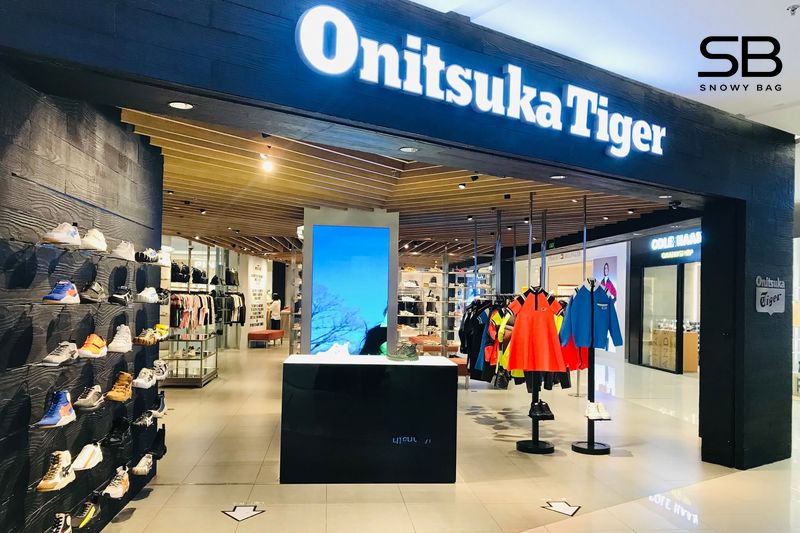 Hình ảnh một cửa hàng Onitsuka Tiger tại TP.HCM với bảng hiệu rõ ràng và khách hàng đang xem giày.