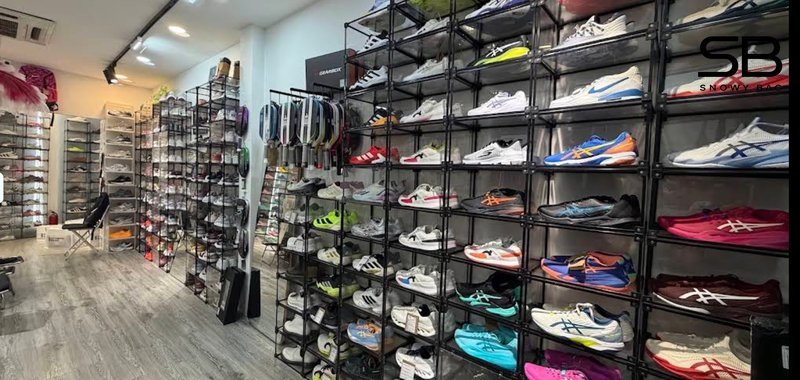 Một khách hàng hài lòng đang cầm túi giày Onitsuka Tiger trước cửa Snowy Store, thể hiện sự tin tưởn